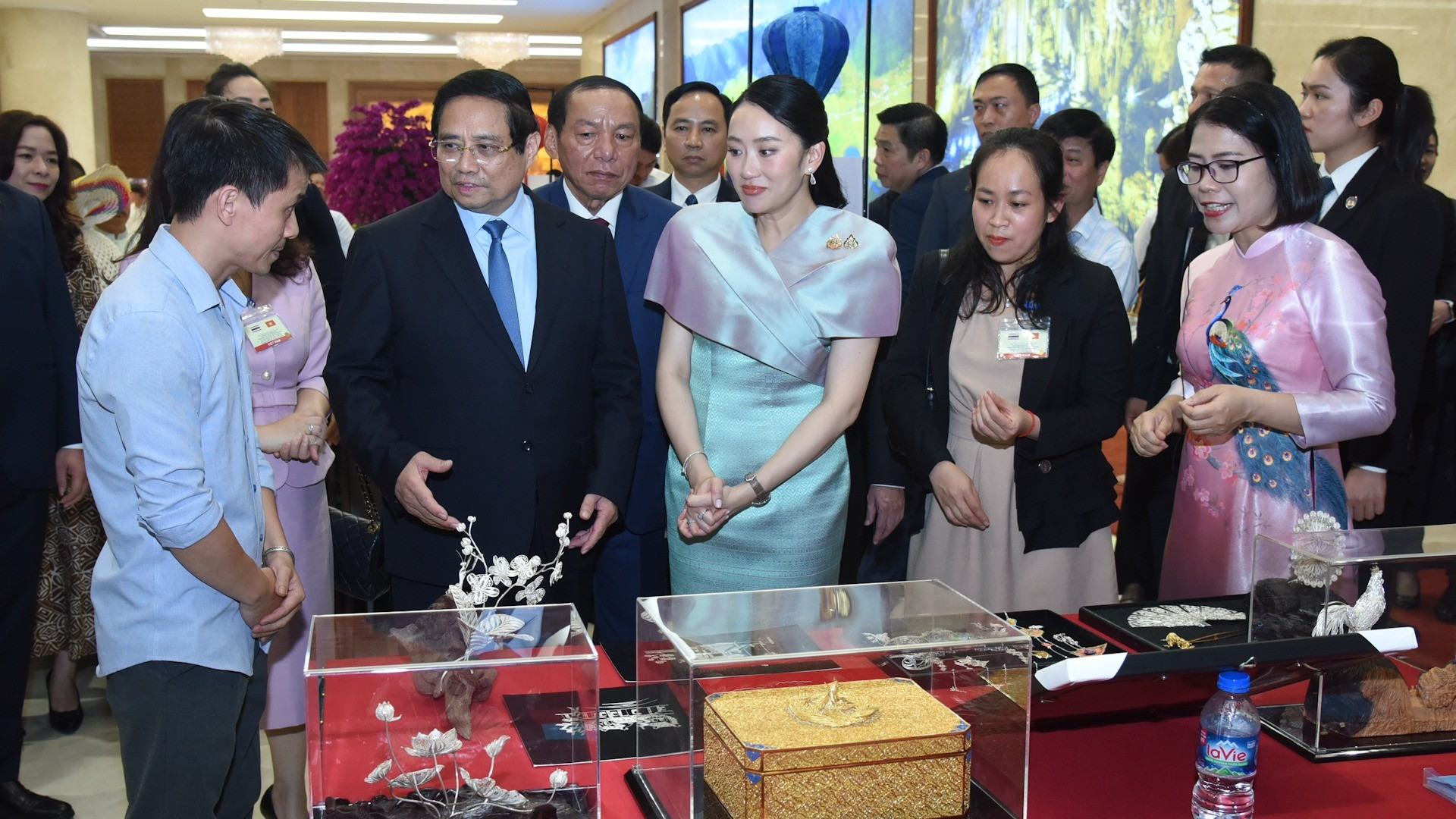 Премьер-министр Фам Минь Тьинь и Премьер-министр Пхетхонгтхан Чинават восхищаются художественно-ремесленными изделиями Вьетнама.