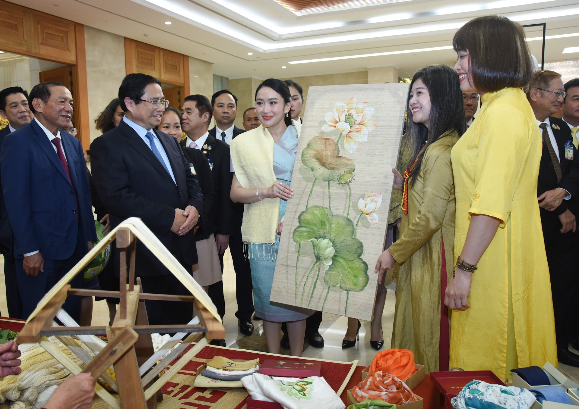Премьер-министр Пхетхонгтхан Чинават рассматривает цветочную картину, выполненную из шёлка.
