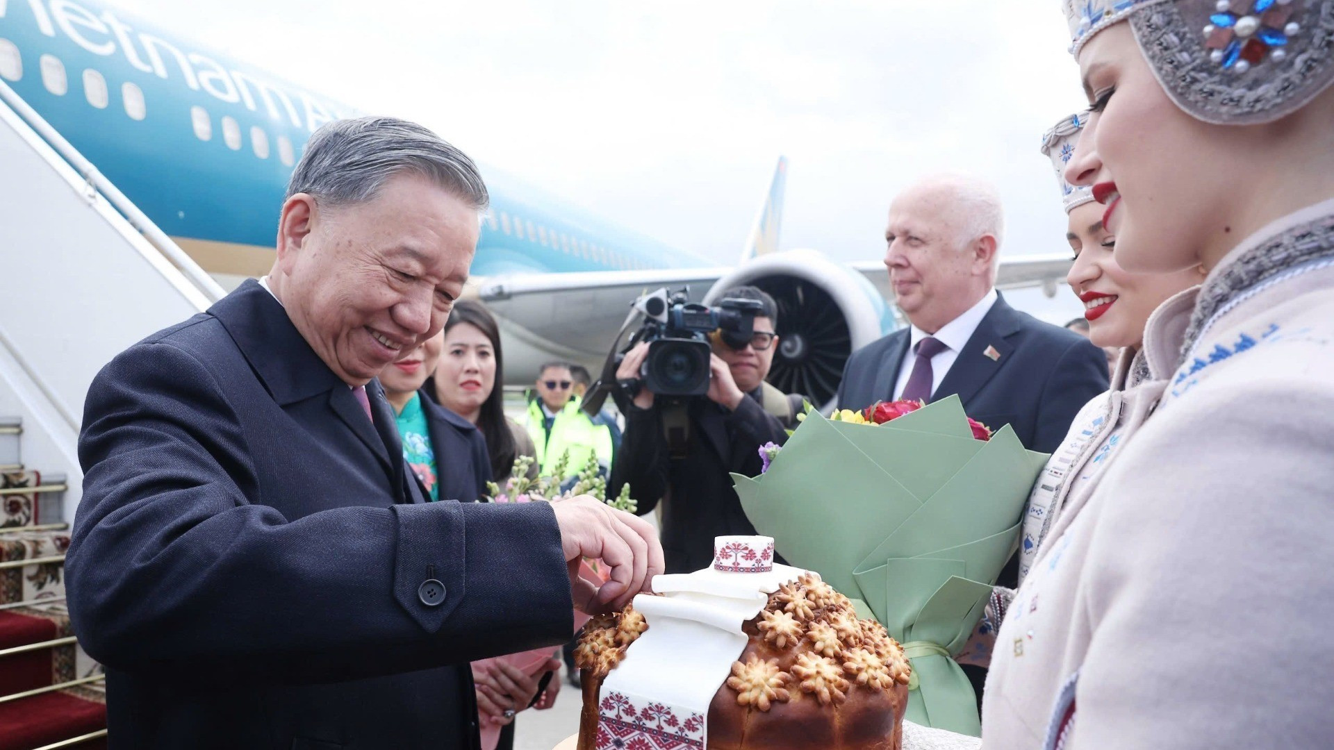 Белорусская девушка в национальном костюме с почтением подносит хлеб и соль Генеральному секретарю ЦК КПВ То Ламу в соответствии с традицией встречи почётных гостей. Фото: ВИА