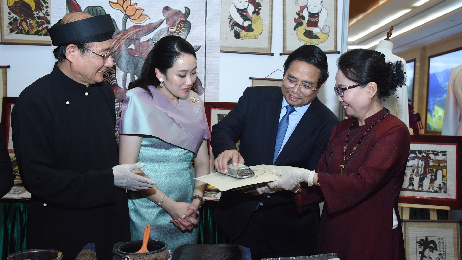 Премьер-министр Фам Минь Тьинь и Премьер-министр Пхетхонгтхан Чинават участвуют в создании народных картин Донгхо.