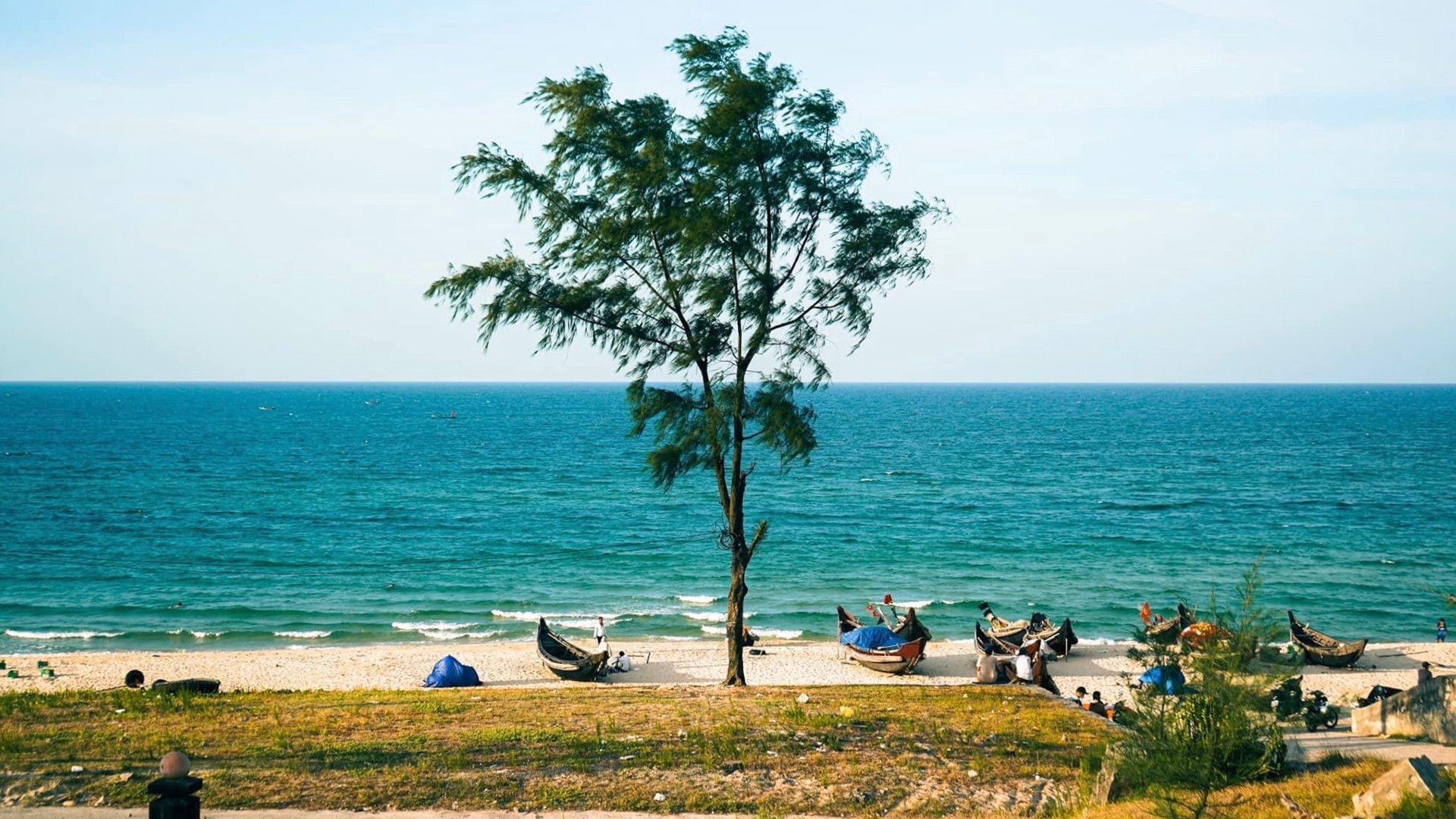 Голубая морская вода вдалеке и маленькие лодки местных жителей, лежащие на песке. Голубая морская вода вдалеке и маленькие лодки местных жителей, лежащие на песке.