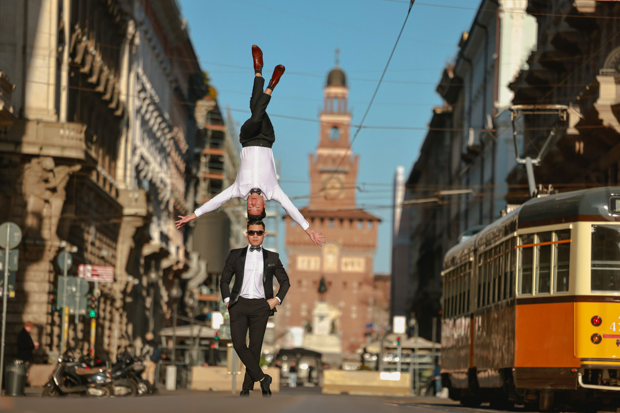 На улице Данте, далеко позади высокая башня замка Сфорца.