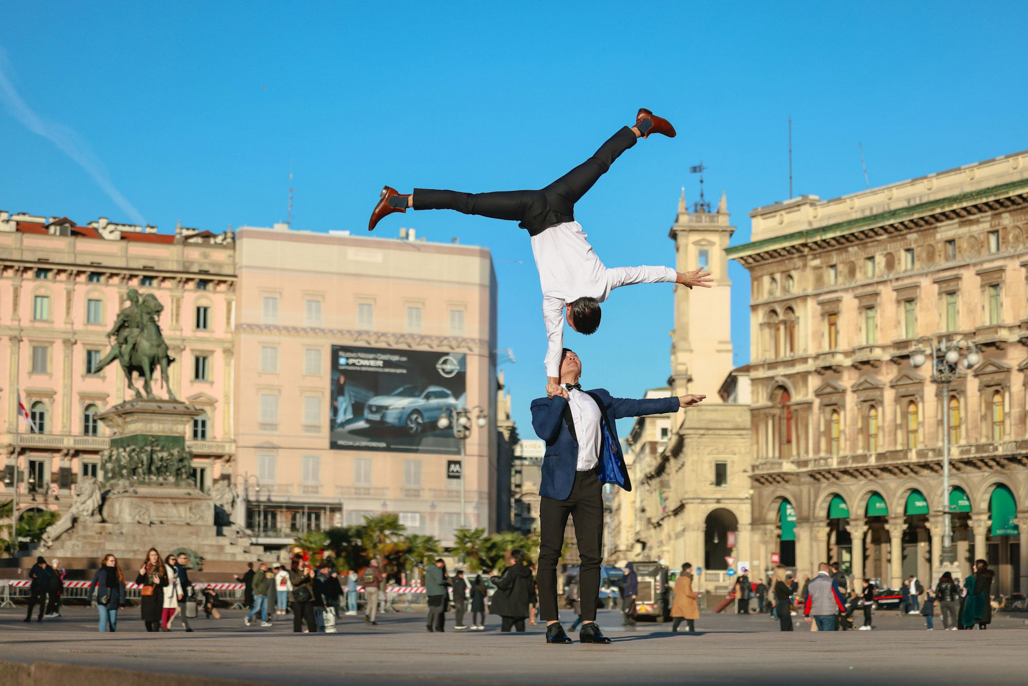 Фотография была снята со ступени у Миланского собора в сторону Памятника Виктору Эммануилу II, расположенного в центре площади Пьяцца-дель-Дуомо в Милане.
