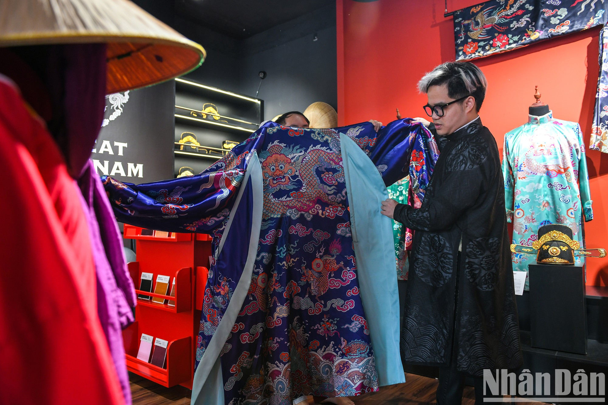 Ву Дык рядом с тщательно отреставрированной моделью старинного костюма.