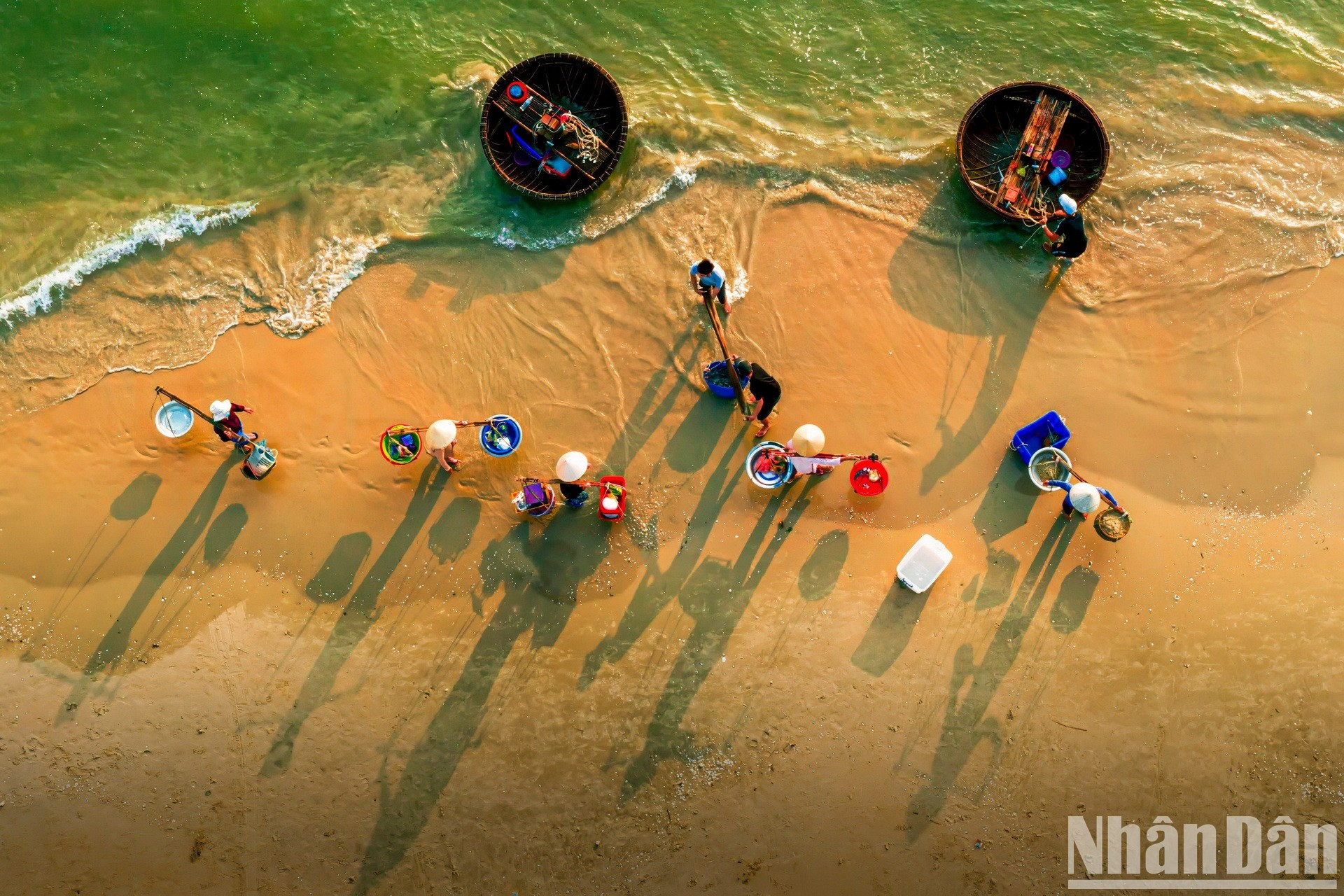 Женщины рыбацкой деревни несут на коромыслах морепродукты на продажу.