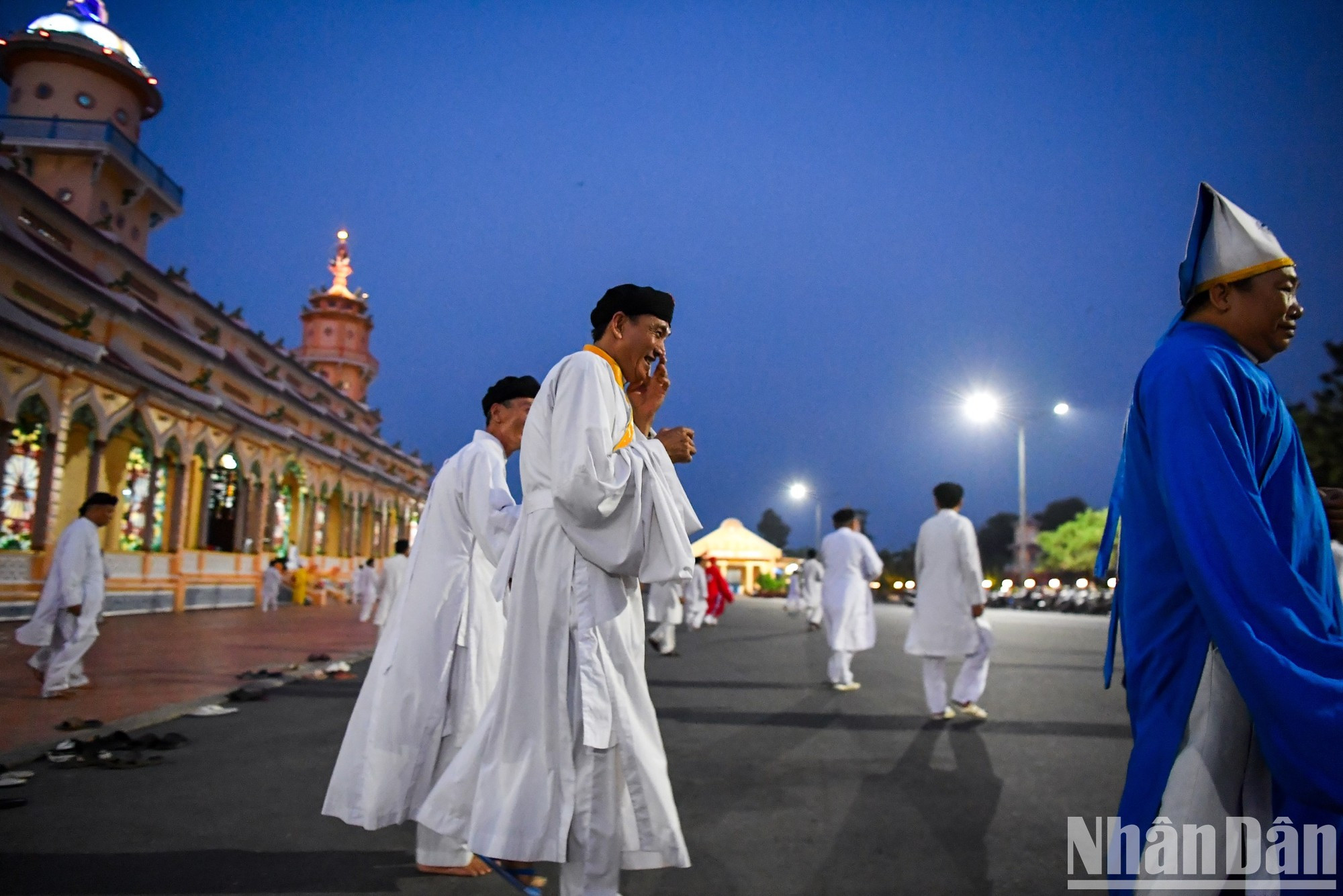 Верующие уходят из Резиденции папы каодаистов после церемонии.