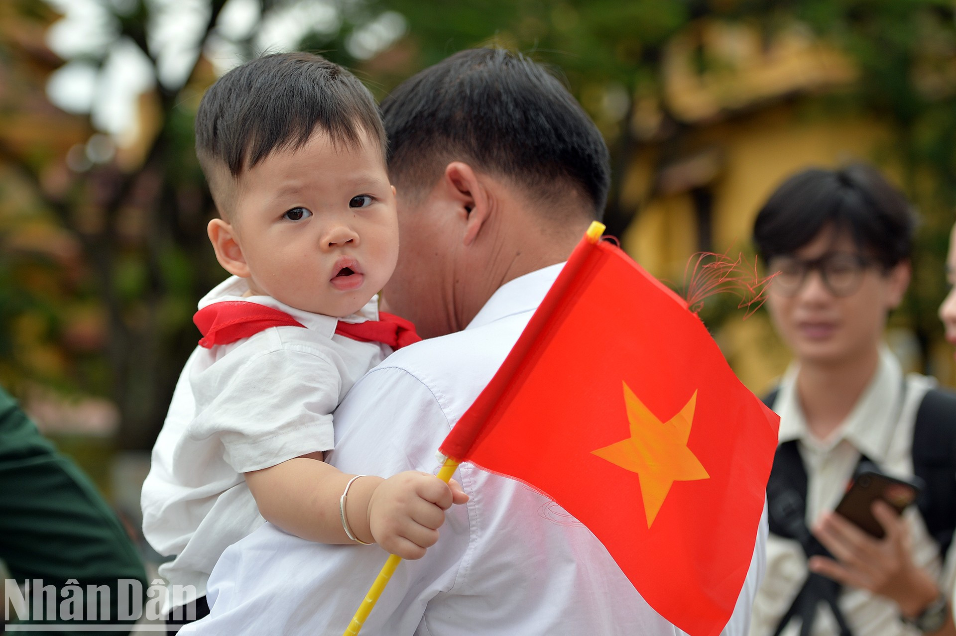 Маленький пионер с красным флагом в руках.