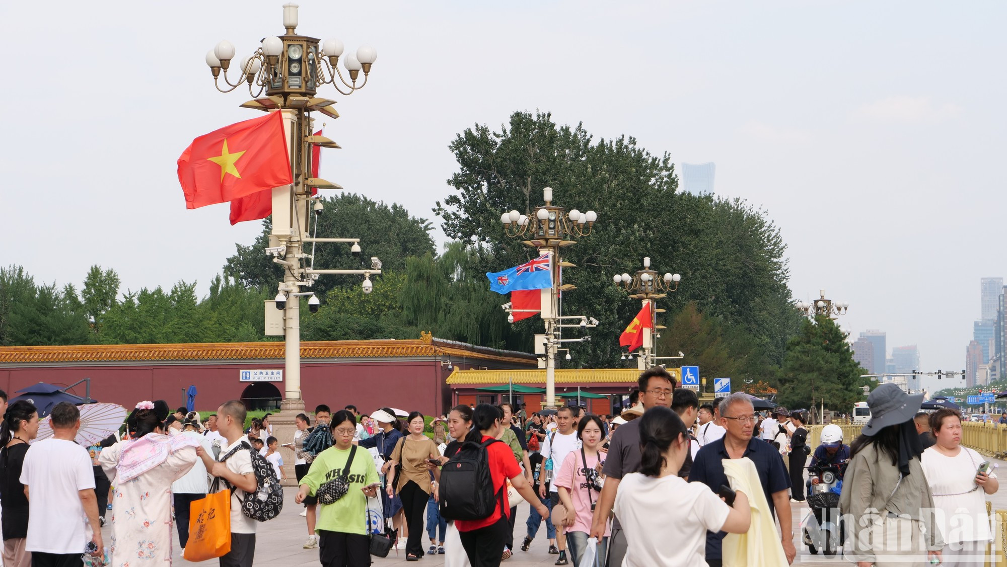 Многие туристы и жители Пекина посещают площадь Тяньаньмэнь, где развевается вьетнамский флаг.