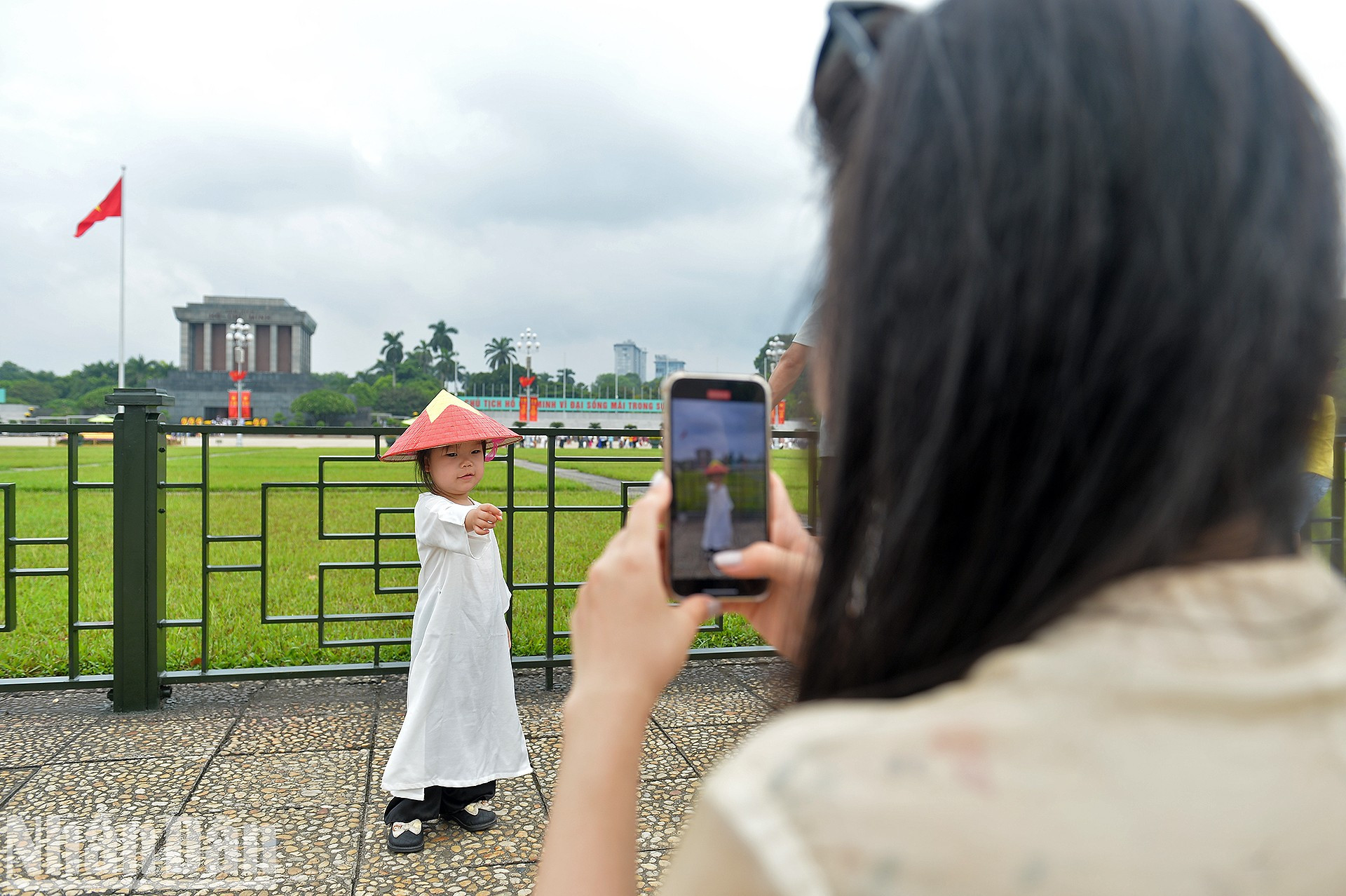 Маленькая жительница Ханоя фотографируется у Мавзолея Хо Ши Мина.