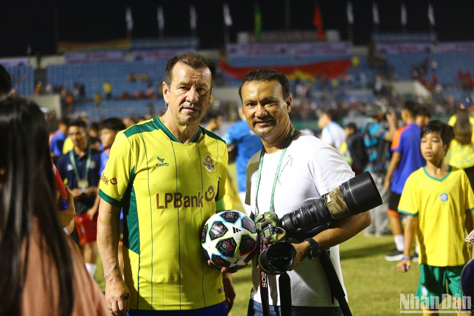 Футбольные фанаты Дананга фотографируются на память с тренером Дунгой.