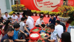 Вьетнамские и камбоджийские сотрудники компании Metfone совместно участвовали в приготовлении пирогов «баньтьынг» в преддверии праздника Тэта. Фото: Хюи Ву