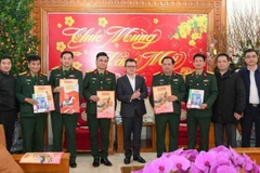 Товарищ Ле Куок Минь (в центре) вручает 325-й дивизии новогодние номера газеты.