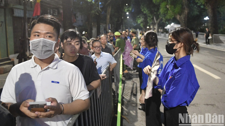 Волонтеры готовы помочь людям, стоящим в очереди, чтобы почтить память Генерального секретаря ЦК КПВ Нгуен Фу Чонга.