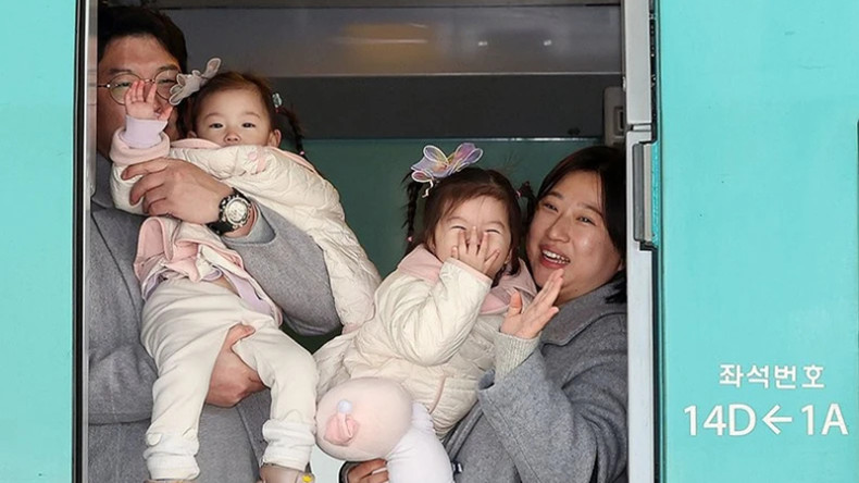 Семья садится на поезд на вокзале Сеула (Южная Корея), чтобы вернуться на малую родину. В настоящее время большинство южнокорейцев приветствует первый день нового года 1 января по солнечному календарю, но они по-прежнему сохраняют традицию собираться вместе во время Нового года по лунному календарю. Фото: Рёнхап