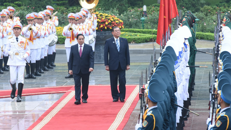 Премьер-министр Вьетнама Фам Минь Тьинь и Премьер-министр Японии Исиба Сигэру обходят строй почетного караула. Фото: Чан Хай
