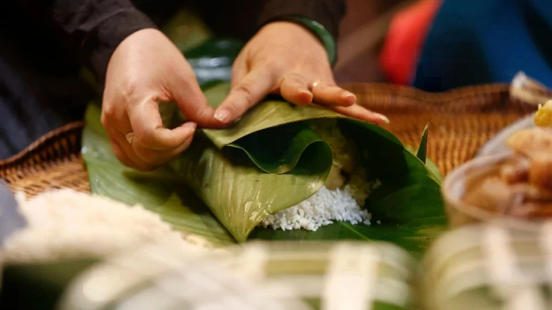 Умелые руки аккуратно заворачивают «баньтьынг», готовясь к традиционному празднованию Тэта. Умелые руки аккуратно заворачивают «баньтьынг», готовясь к традиционному празднованию Тэта.