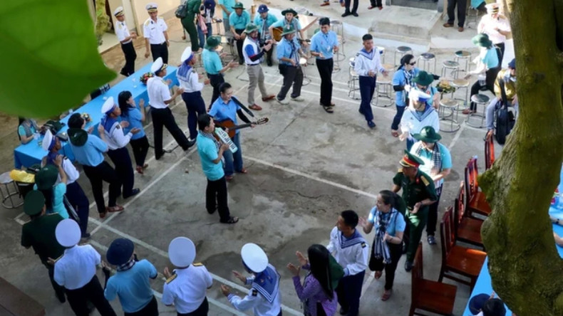 Офицеры и солдаты на острове Анбанг поют вместе с делегатами, которые пересекли море для посещения острова. Офицеры и солдаты на острове Анбанг поют вместе с делегатами, которые пересекли море для посещения острова.