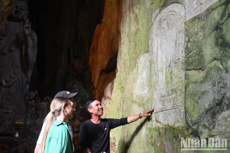 Иностранные туристы знакомятся с надписями на достопримечательности Нгуханьшон. Иностранные туристы знакомятся с надписями на достопримечательности Нгуханьшон.
