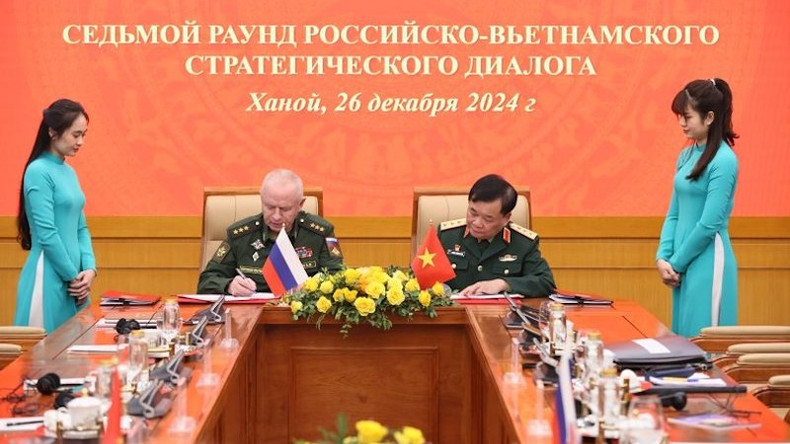 Генерал-полковник Хоанг Суан Тьиен и генерал-полковник Александр Фомин пописывают документы о сотрудничестве.