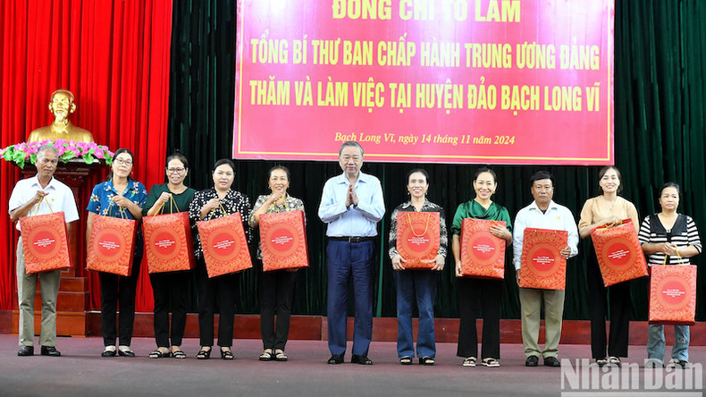 Генеральный секретарь ЦК КПВ То Лам вручает подарки жителям островного уезда Батьлонгви.