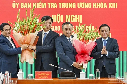 Премьер-министр Фам Минь Тьинь и постоянный член Секретариата Чан Кам Ту вручают цветы с поздравлением Секретарю Парткома Нгуен Зюи Нгоку и Председателю Контрольно-ревизионной комиссии ЦК КПВ Чан Ши Тханю. Фото: Тхюи Нгуен