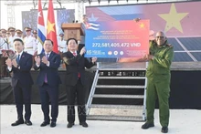 Заместитель Премьер-министра Хо Куок Зунг передаёт символический чек Вице-президенту Республики Куба Сальвадору Вальдесу Месе — сумму второго транша программы пожертвований в поддержку народа Кубы «65 лет солидарности Вьетнама и Кубы», организованной Обществом Красного Креста Вьетнама. (Фото: ВИА)