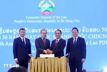 Генеральный консул Лаоса в Дананге Супхань Хадаохеуанг, Постоянный заместитель секретаря Парткома г. Дананга Нгуен Динь Винь и делегаты разрезают праздничный торт. (Фото: ВИА)