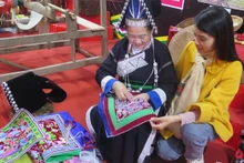 Посетители знакомятся с традиционным вышивальным ремеслом народности Па Зи в коммуне Мыонгкхыонг. (Фото: ВИА)