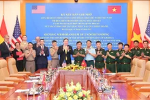 Генерал-полковник Хоанг Суан Тьен, заместитель министра национальной обороны, Посол США во Вьетнаме Марк Кнаппер и делегаты после подписания. (Фото: ВИА)