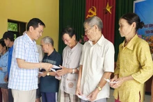 Представитель газеты «Нянзан» в провинции Куангчи передает денежную помощь жителям деревни Хойки в общине Намхайланг.