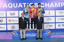 Хюи Хоанг стоит по центру на пьедестале, получая золотую медаль чемпионата Азии.