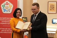 Студент МГИМО передает Музею Хо Ши Мина книгу с опубликованным выступлением Дядюшки Хо на пятом конгрессе Коминтерна. (Фото: Суан Хынг)