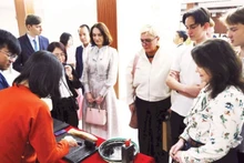 Иностранные гости с удовольствием знакомятся с искусством печати с деревянных клише. (Фото: nhandan.vn)