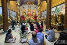 Представители вьетнамской общины в Лаосе с благоговением возносят молитвы о мирном и счастливом новом годе. (Фото: Зюи Тоан)