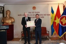 Посол Чан Ван Туан вручил медаль «За заслуги в области культуры, спорта и туризма» кинорежиссёру Бо Элену. (Фото: Посольство Вьетнама в Швеции)