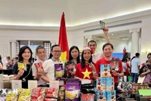 Посол Вьетнама в Шри-Ланке Чинь Тхи Там, сотрудники и супруги сотрудников Посольства Вьетнама в Шри-Ланке фотографирутся у вьетнамского стенда. (Фото: ВИА)