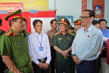 Заместитель председателя НС Чан Куанг Фыонг (справа) проверяет работу по организации выборов на избирательном участке № 1 (посёлок Кеньдао, коммуна Датмуй). (Фото: ВИА)