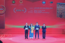 Заведующий Отделом ЦК КПВ по пропаганде, политическому воспитанию и работе с народными массами Чинь Ван Кует вручает премию А авторам и авторским коллективам — лауреатам премии. (Фото: ВИА)