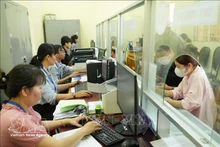 Государственные служащие в коммуне Тхайми (город Хошимин) рассматривают административные документы для граждан. (Фото: ВИА)