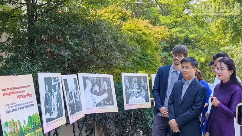 Г-жа Ле Тхи Фыонг представляет выдающиеся фотографии о жизни и революционной деятельности Президента Хо Ши Мина директору Музея живой истории Томасу Ле Гоффу (слева). 