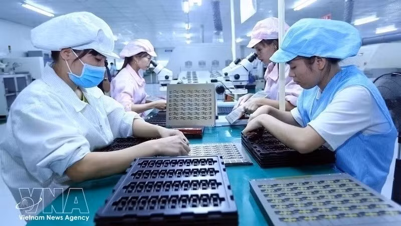 Работница собирает электронные компоненты на производственной линии компании Баошен (провинция Бакзянг). Фото: ВИА 