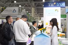 Представители предприятий знакомятся с продукцией TH на выставке. (Фото: Тхань Тхэ)