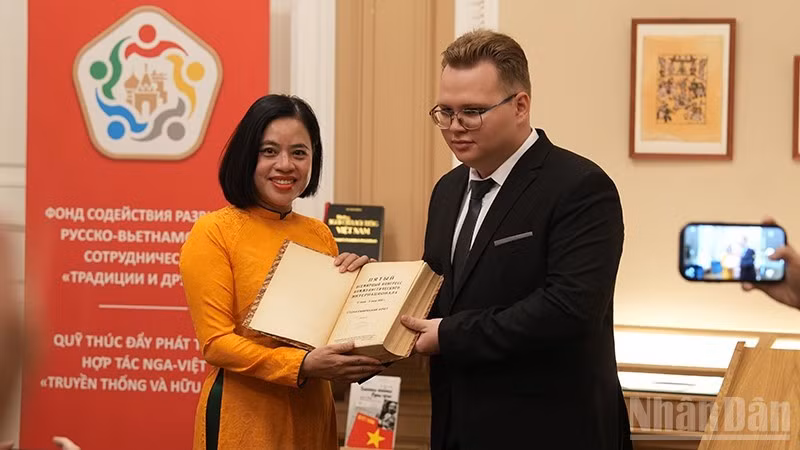 Студент МГИМО передает Музею Хо Ши Мина книгу с опубликованным выступлением Дядюшки Хо на пятом конгрессе Коминтерна. (Фото: Суан Хынг)