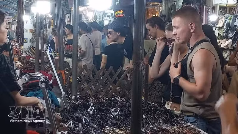 Иностранные туристы любят покупать сувениры на ночном рынке в Старом квартале Ханоя. (Фото: ВИА)