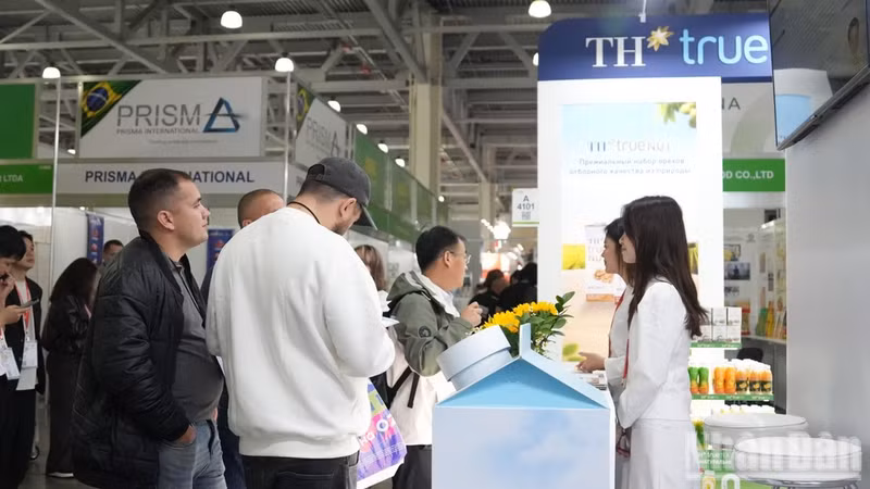Представители предприятий знакомятся с продукцией TH на выставке. (Фото: Тхань Тхэ)