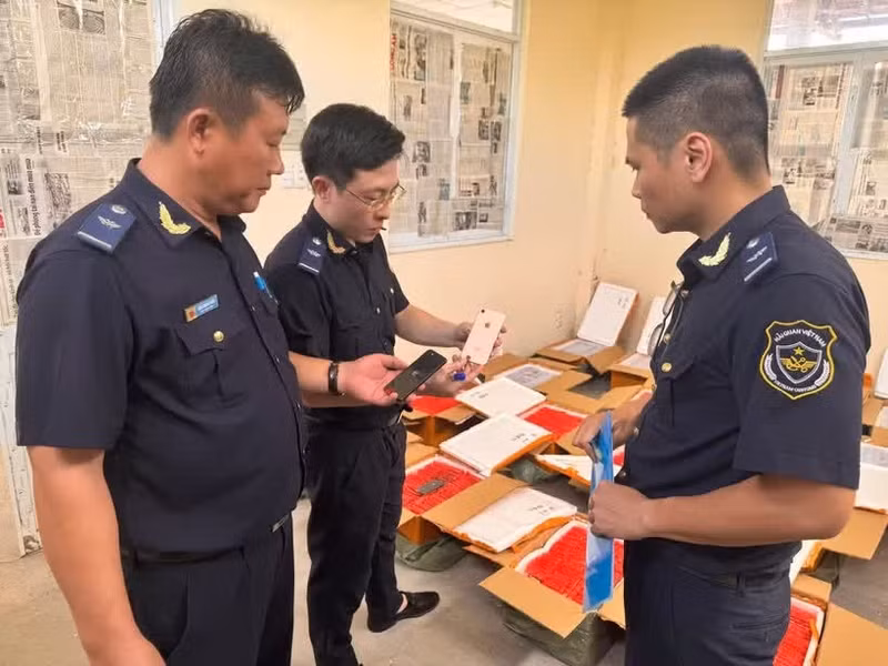 Сотрудники таможенной службы проводят проверку транзитной партии мобильных телефонов, вызвавшей подозрение в том, что товар является бывшим в употреблении и не имеет указания происхождения.