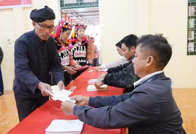 Первые избиратели деревни Та Мьеу общины Синтхау провинции Дьенбьен получают избирательные бюллетени. Фото: ВИА