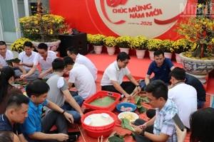 Вьетнамские и камбоджийские сотрудники компании Metfone совместно участвовали в приготовлении пирогов «баньтьынг» в преддверии праздника Тэта. Фото: Хюи Ву