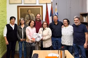 Посол Вьетнама Нго Минь Нгует фотографируется на память с представителями Коммунистической партии Уругвая. Фото: ВИА