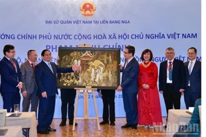 Премьер-министр Фам Минь Тьинь вручает памятную подарку Посольству Вьетнама в России. Фото: Тхань Зянг 